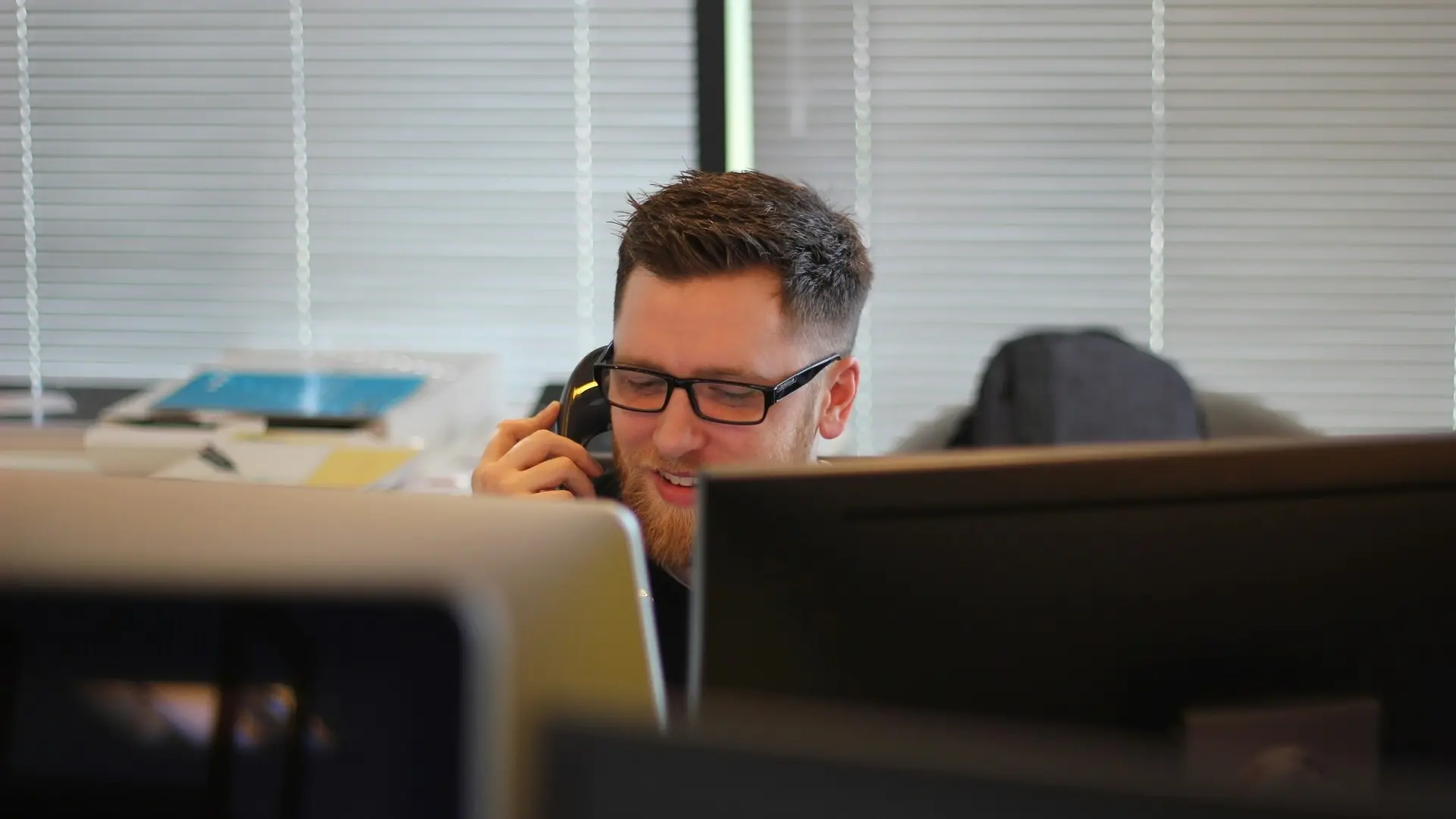 Persona utilizando un sistema de telefonía IP en una oficina moderna.